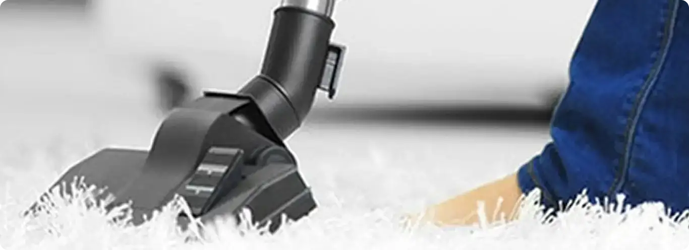 Close-up of a professional vacuuming a white carpet in Deerfield Beach.